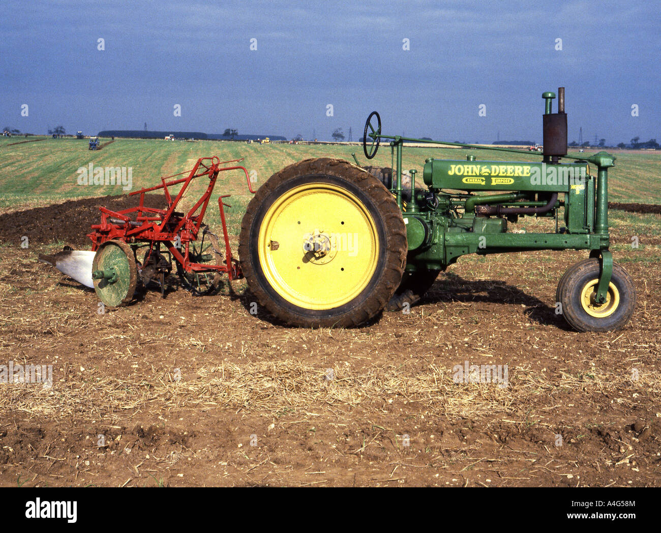 Vintage John Deere tractor with plough at ploughing competition Stock
