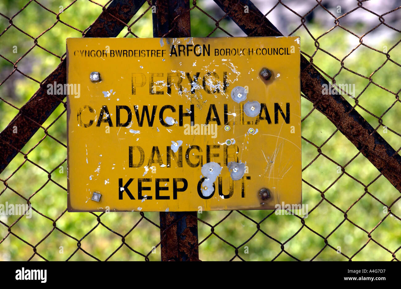 Bilingual Welsh English language danger sign on a disused slate quarry near Llanberis in Snowdonia Gwynedd North Wales UK Stock Photo