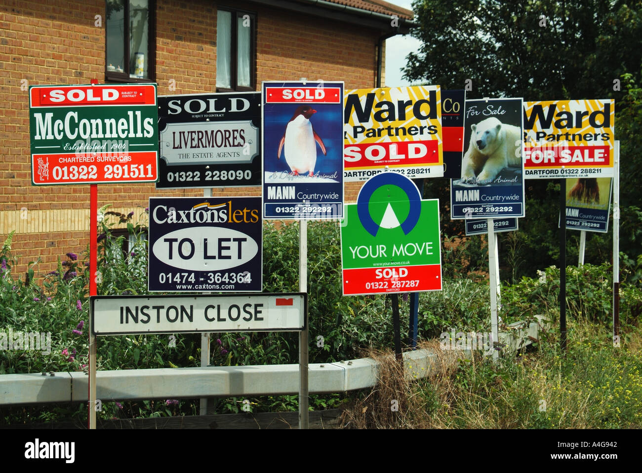 Estate and letting agents advertising boards placed at junction of culdesac and main road Stock Photo