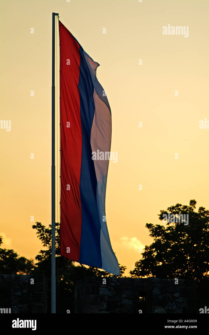 Serb Flag Flying From A Flagpole at Dusk Stock Photo