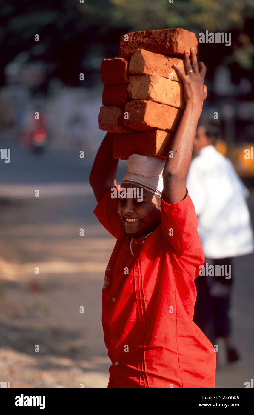 Woman carrying bricks on her head at a construction site in Chennai (Madras), India. Stock Photo