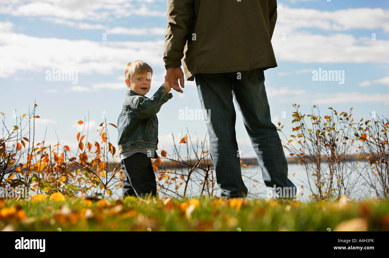 Boy holding onto his grandpa's hand, Sylvan Lake, Alberta, Canada Stock Photo