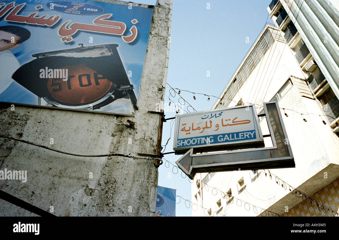 A bilingual sign for a shooting gallery and buildings in Amman, Jordan. Stock Photo