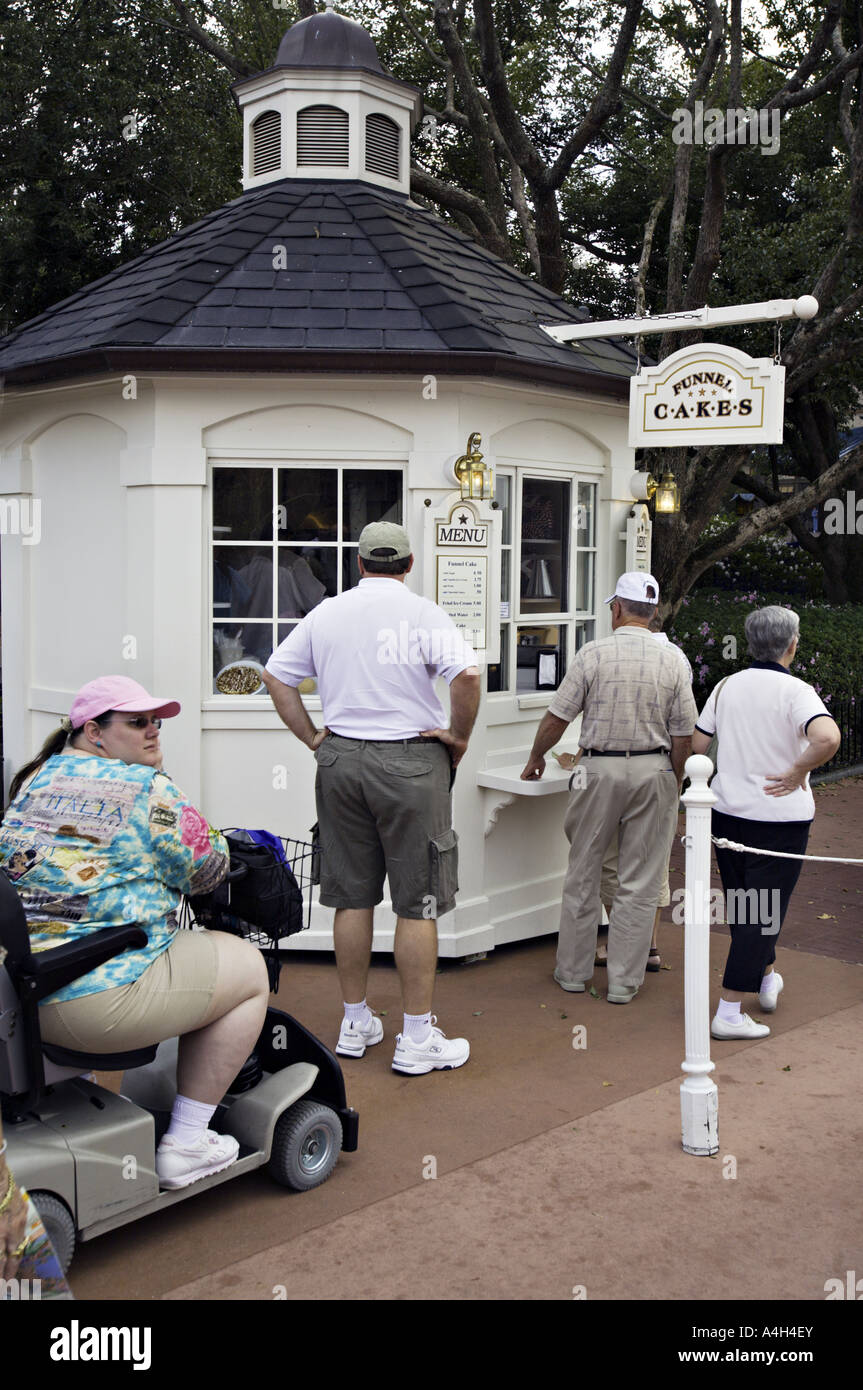 FLORIDA ORLANDO Morbidly obese woman in an electric scooter waits in line to buy funnel cakes Stock Photo