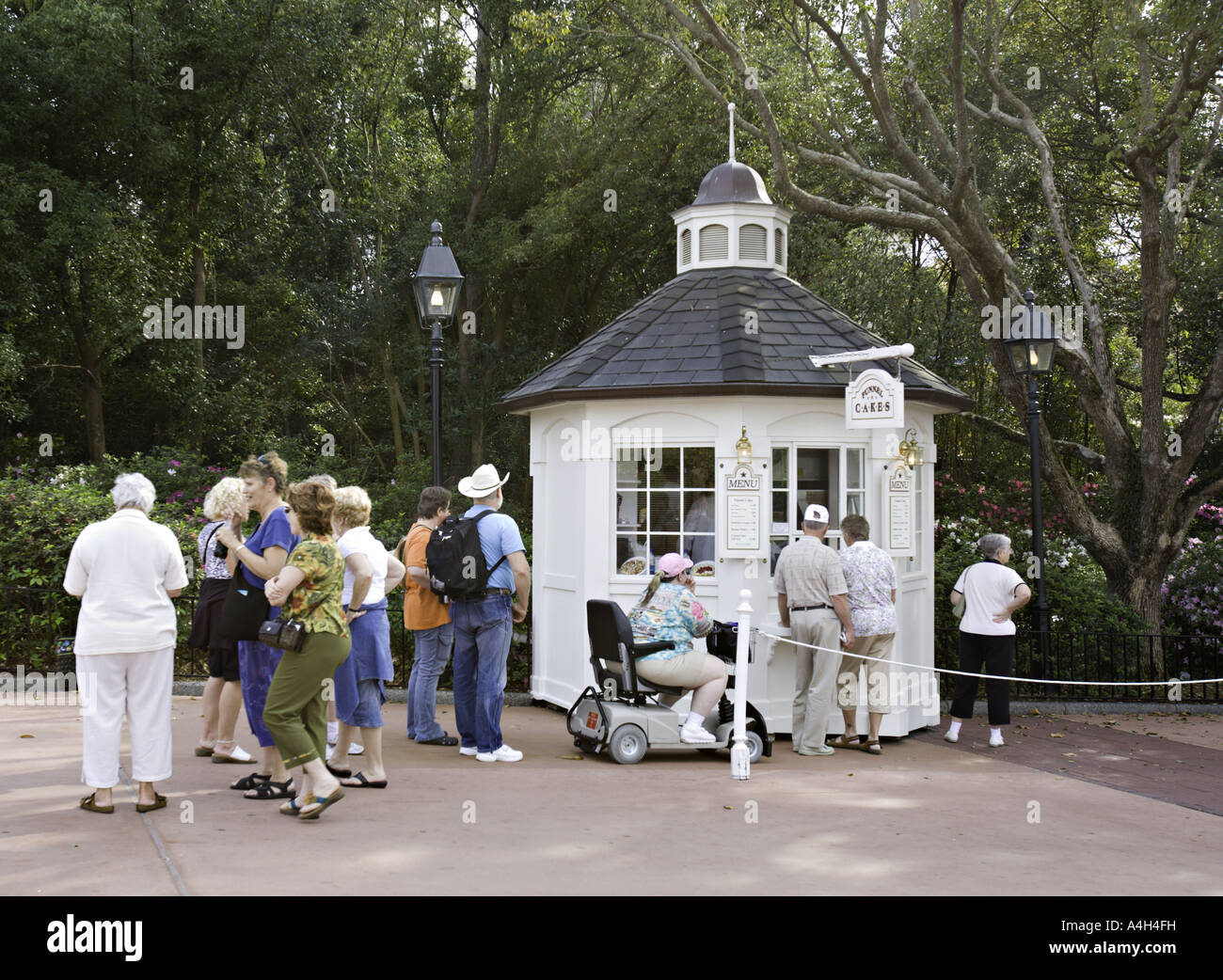 FLORIDA ORLANDO Morbidly obese woman in an electric scooter waits in line to buy funnel cakes Stock Photo