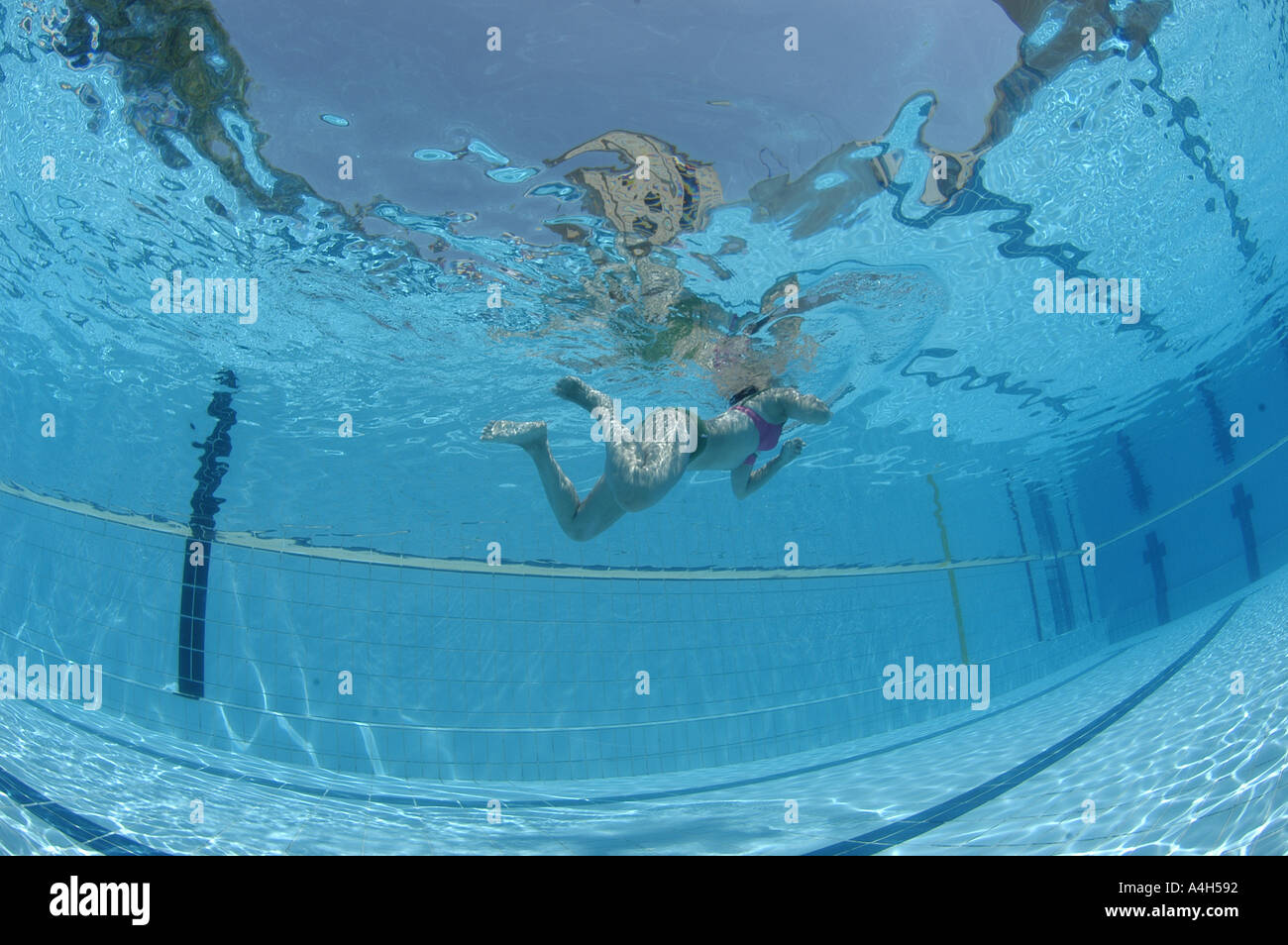 Spanish young woman swimming underwater view on a swimming pool