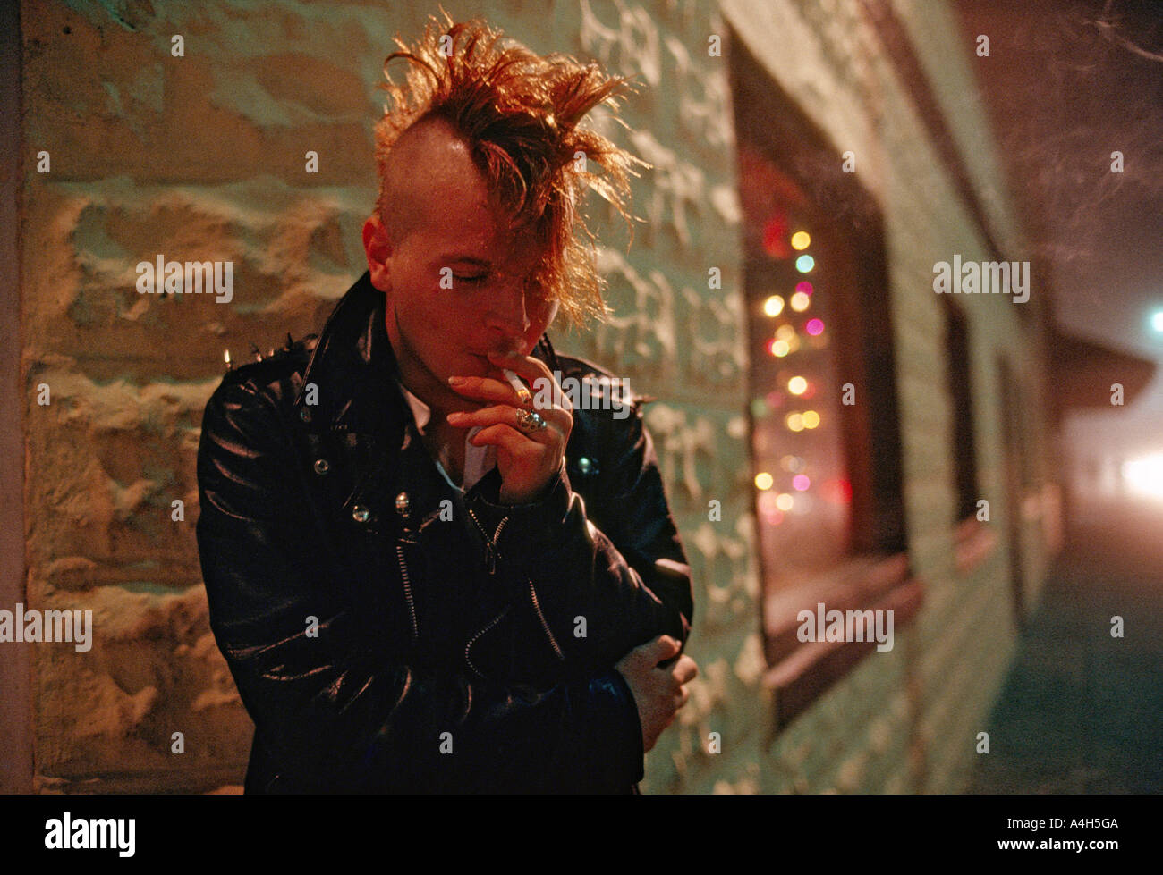 Young Man With Mohawk Haircut Smokes A Cigarette Outside An