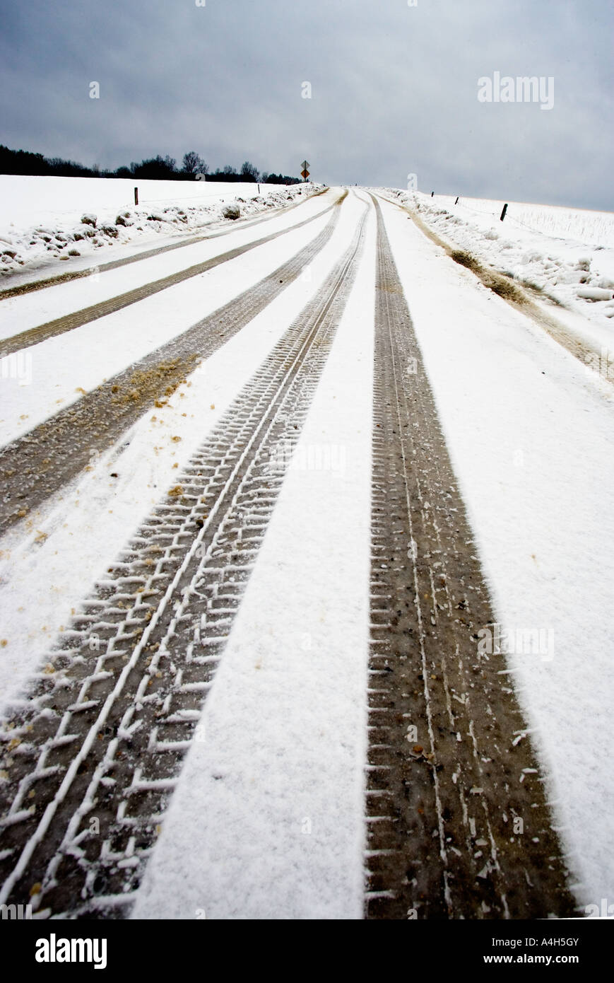 Tire tracks along snowy country road Stock Photo - Alamy