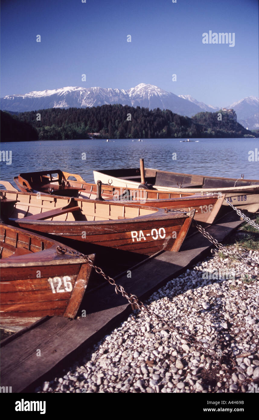 Rowingboats on lake Bled at sunset with mountains and castle in the ...
