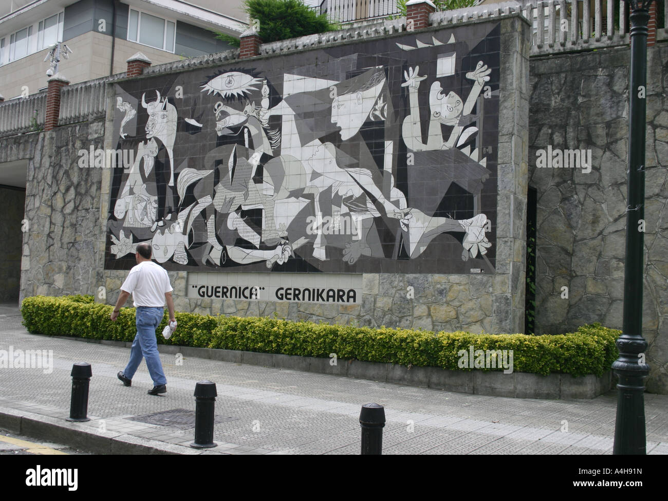 Man walking past tiled street mural of Picasso's Guernica in the town of Guernica, Biscay, Basque Country, Spain Stock Photo