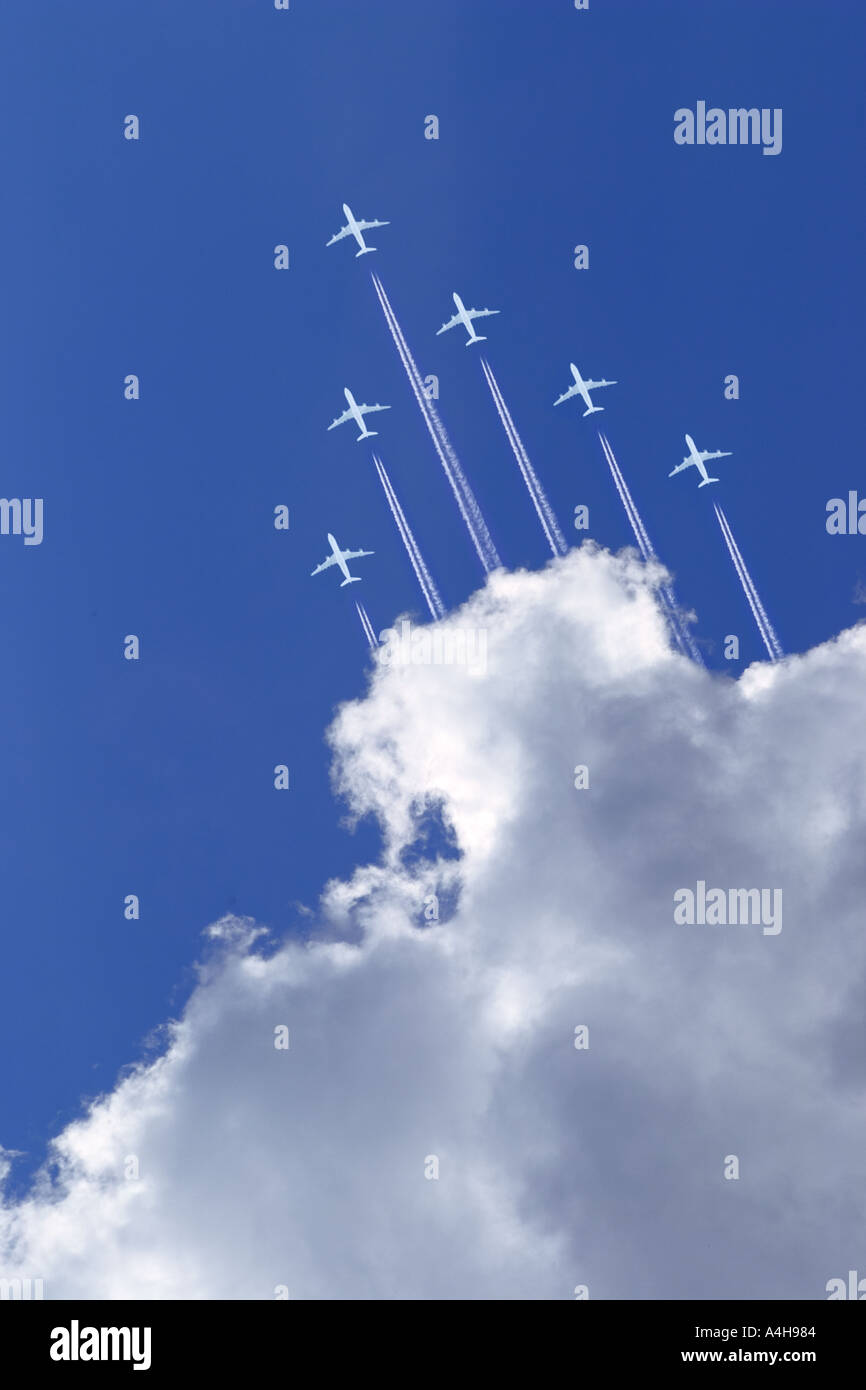 white passenger jets with vapor trails in blue sky and high altitude Stock Photo
