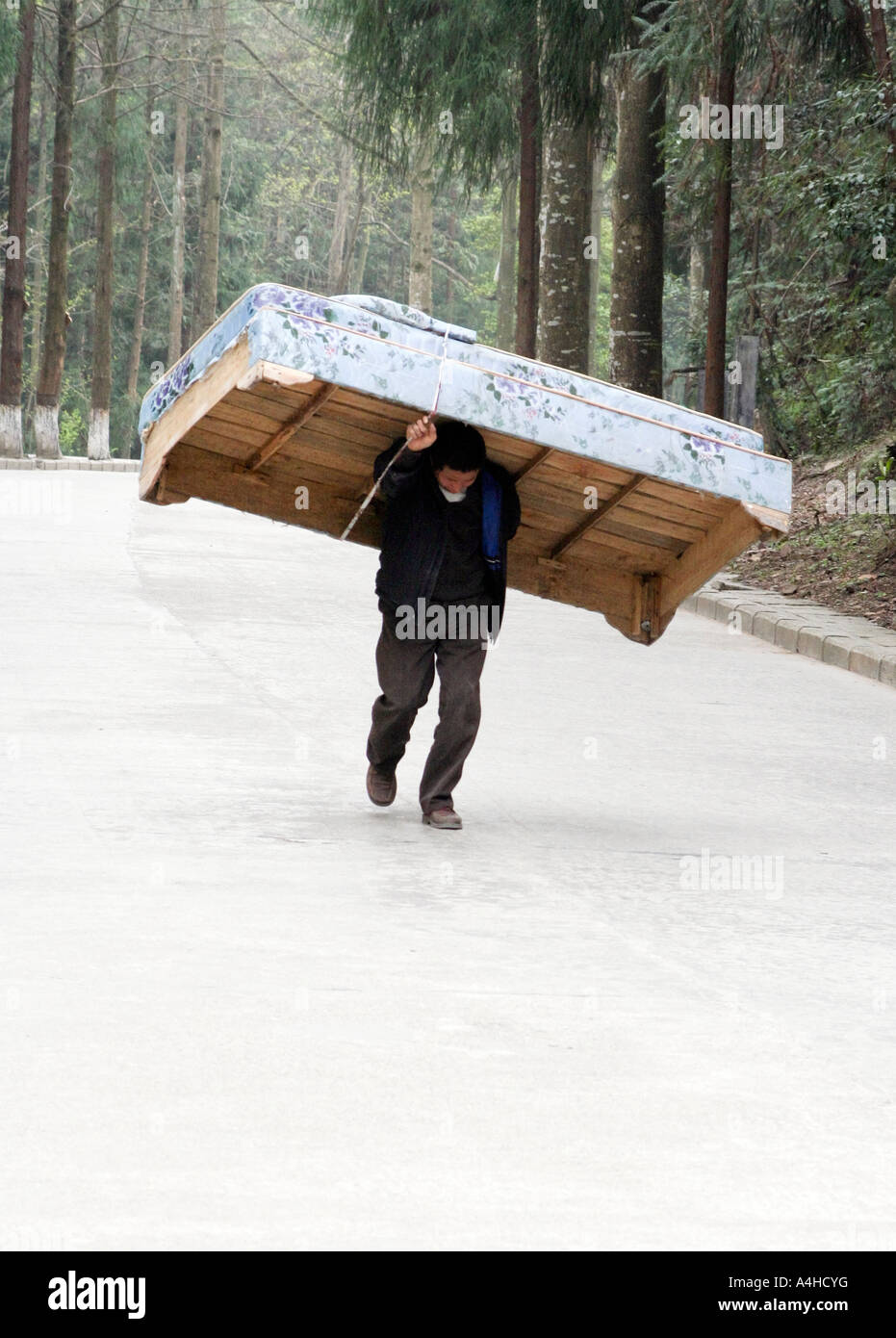 man carrying bed in China Stock Photo Alamy