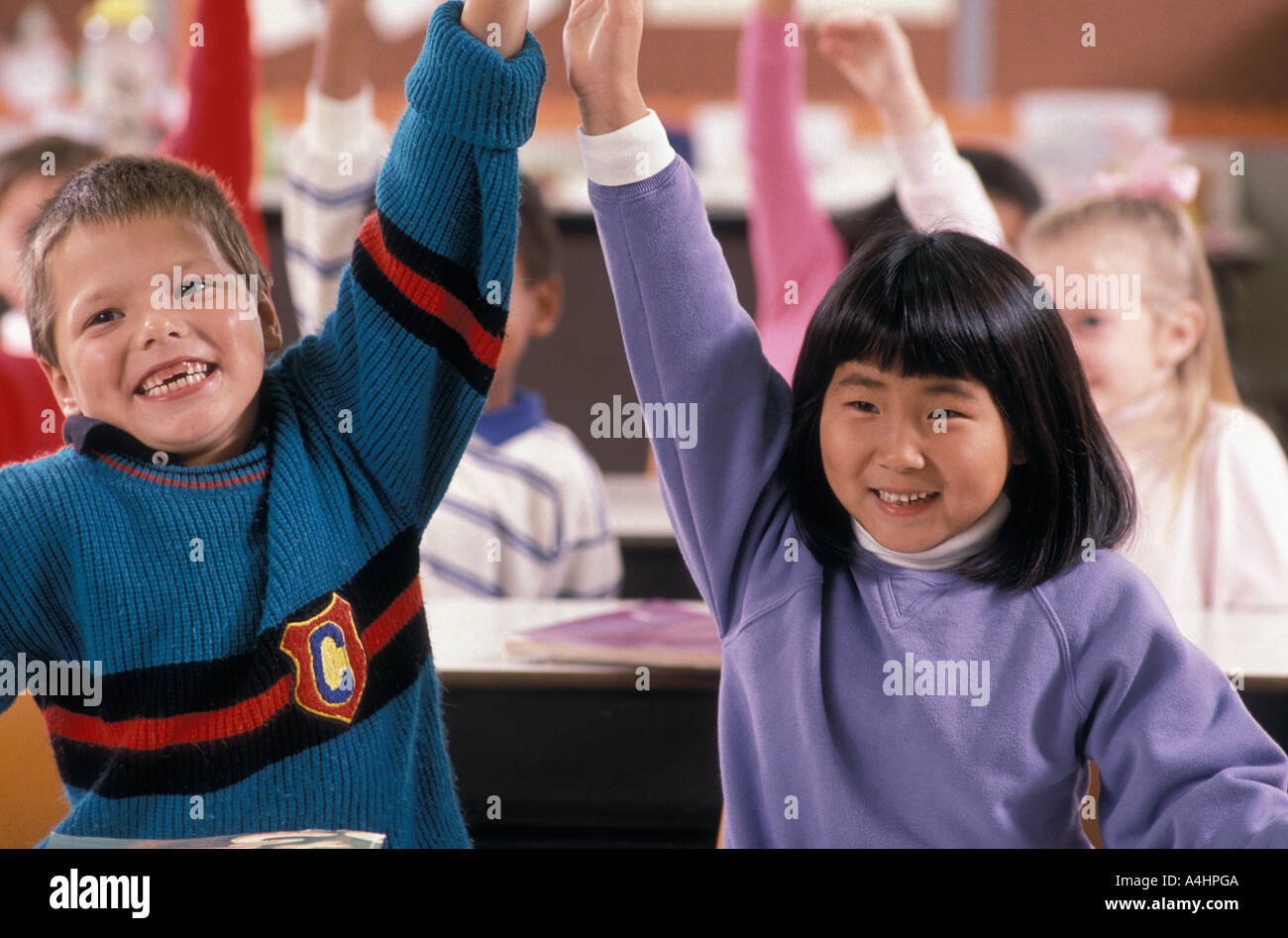 Students raising hands in class Stock Photo