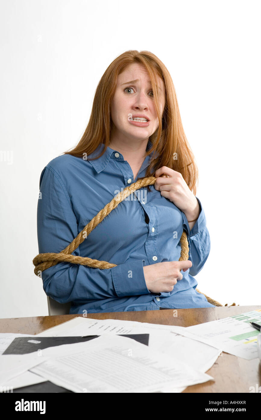 Desperate woman tied to her office chair Stock Photo