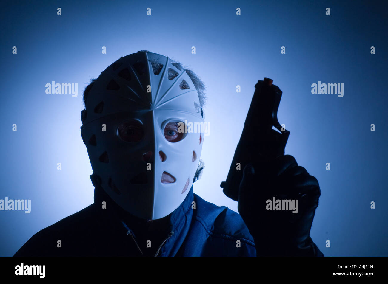 conceptual view of burglar wearing ice hockey mask with hand gun drawn  Stock Photo - Alamy