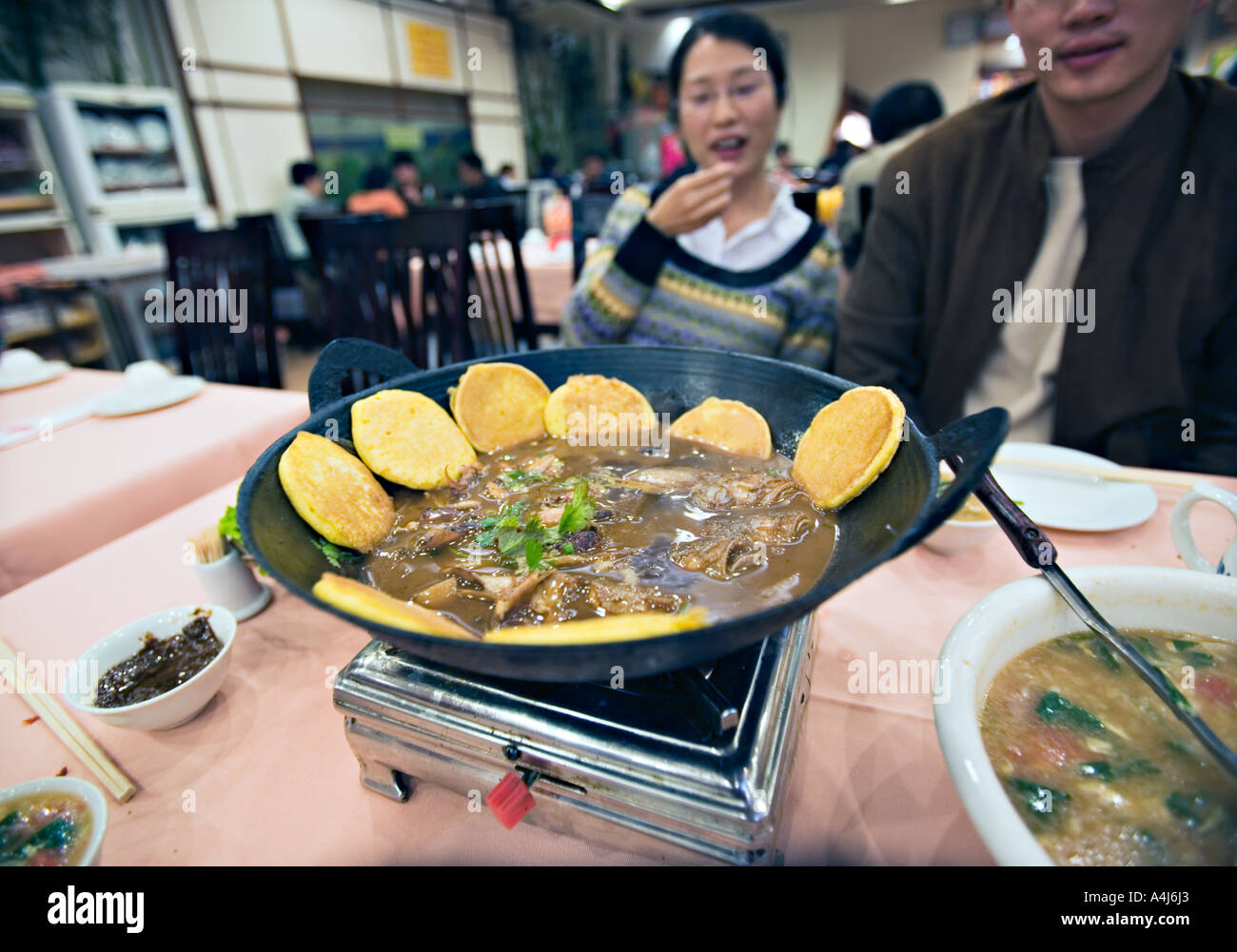 CHINA BEIJING Young Chinese couple eating fish head soup and corn cakes