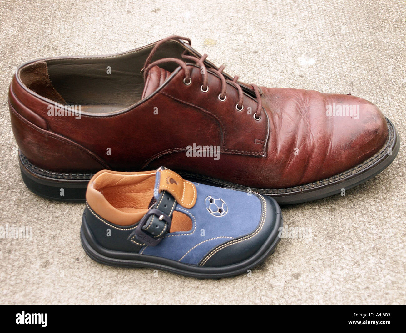 A pair of adult shoes next to a very small pair of toddler or boy child  shoes Stock Photo - Alamy