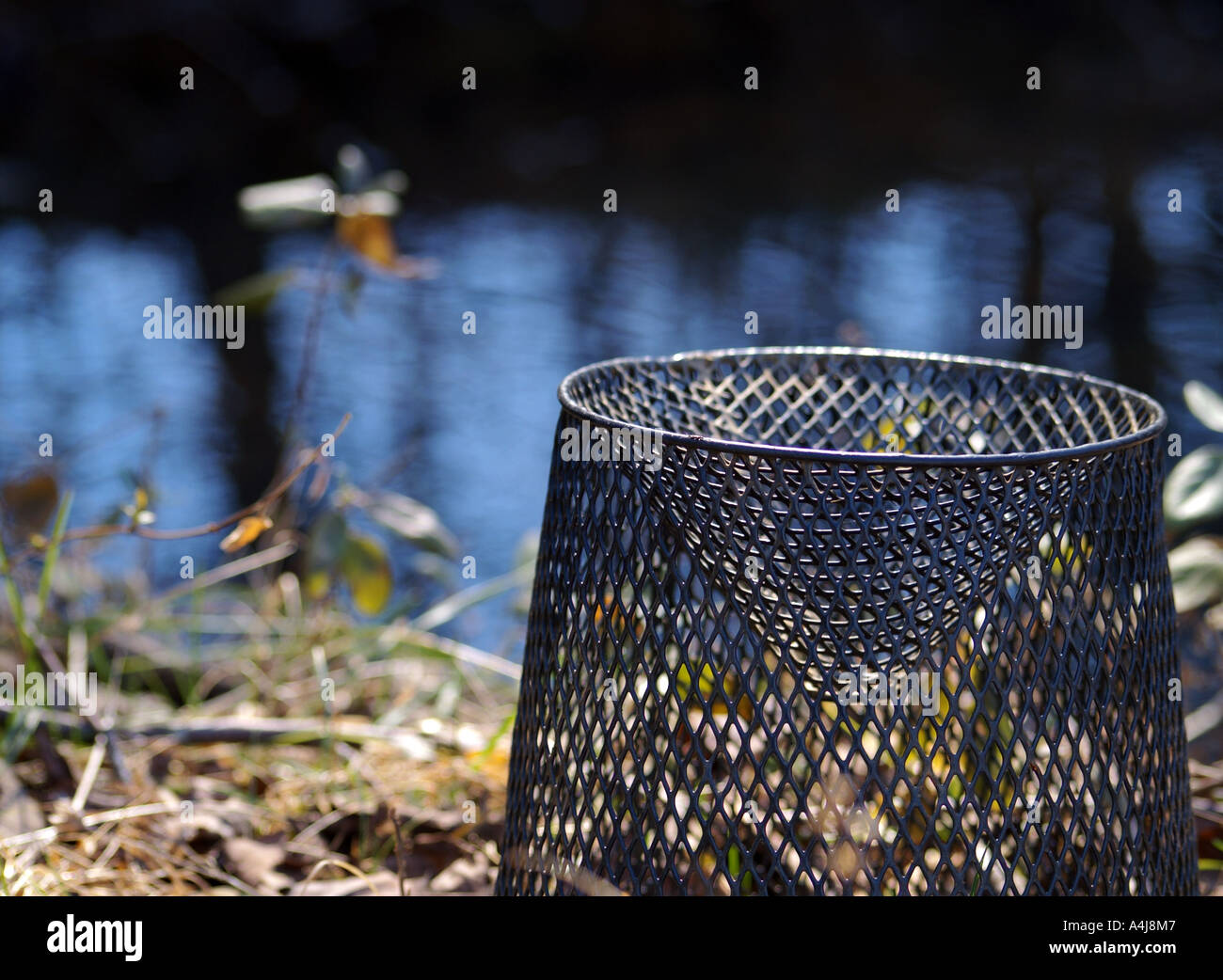 Minnow trap left on the stream bank, waiting for warmer weather to arrive. Stock Photo