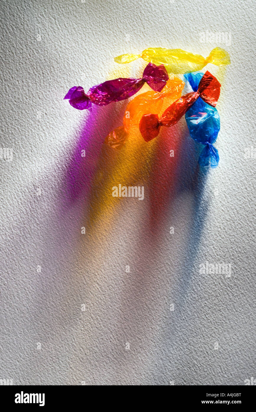 cellophane sweet wrappers with light shining through on textured paper Stock Photo