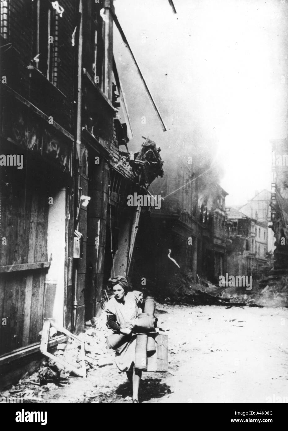 A woman leaving her burning house in a bombed street, Germany, 1945. Artist: Unknown Stock Photo
