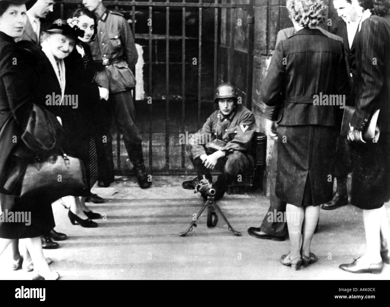 Civilians in front of a German guard post with a machine gun, Paris, June 1940. Artist: Unknown Stock Photo