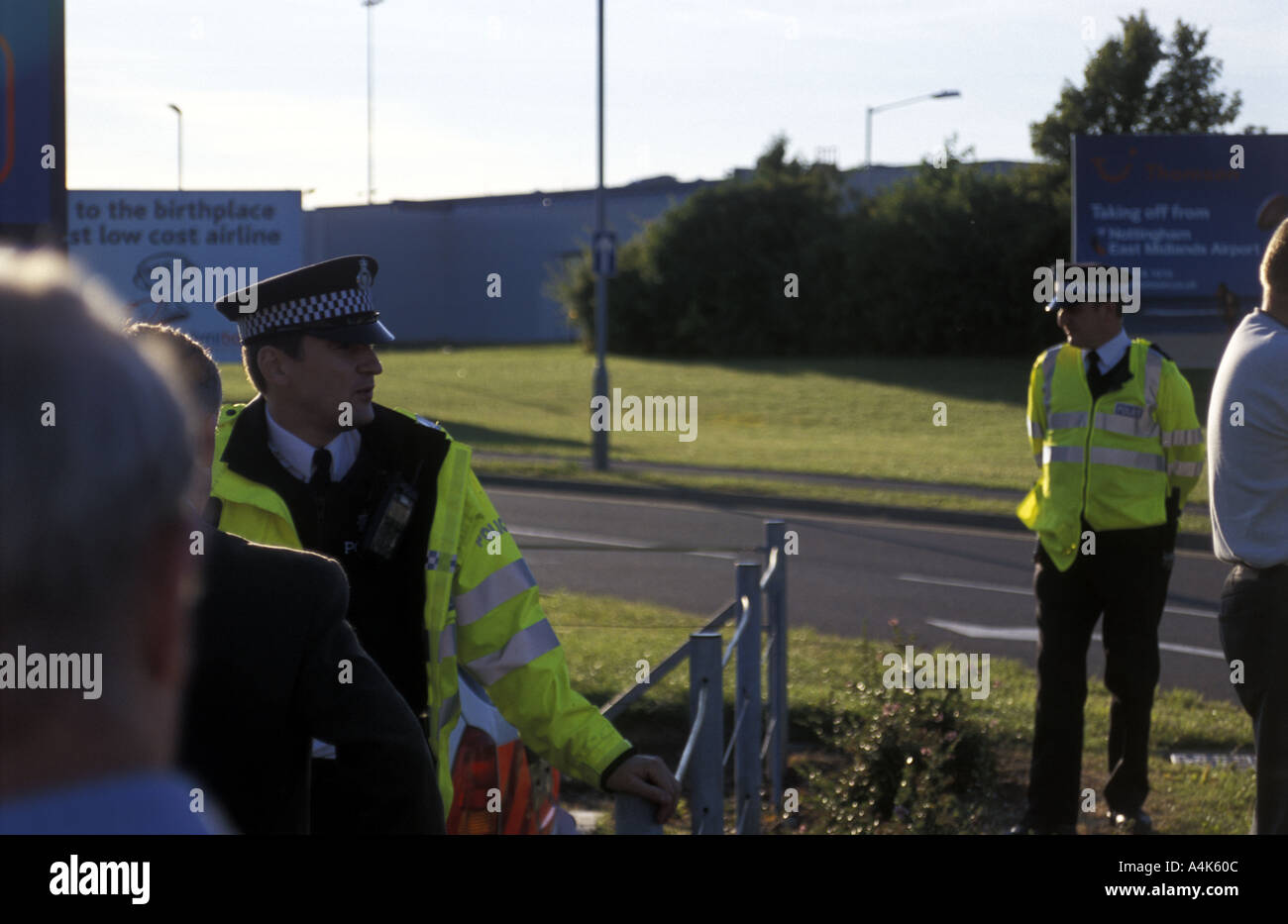 Police officer directs passengers evacuated from airport during security alert Stock Photo