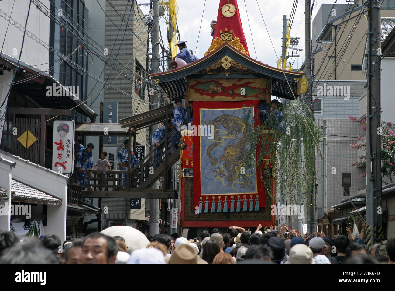 A festival float from the Gion Matsuri makes its way through the narrow backstreets of Gion Japan Stock Photo