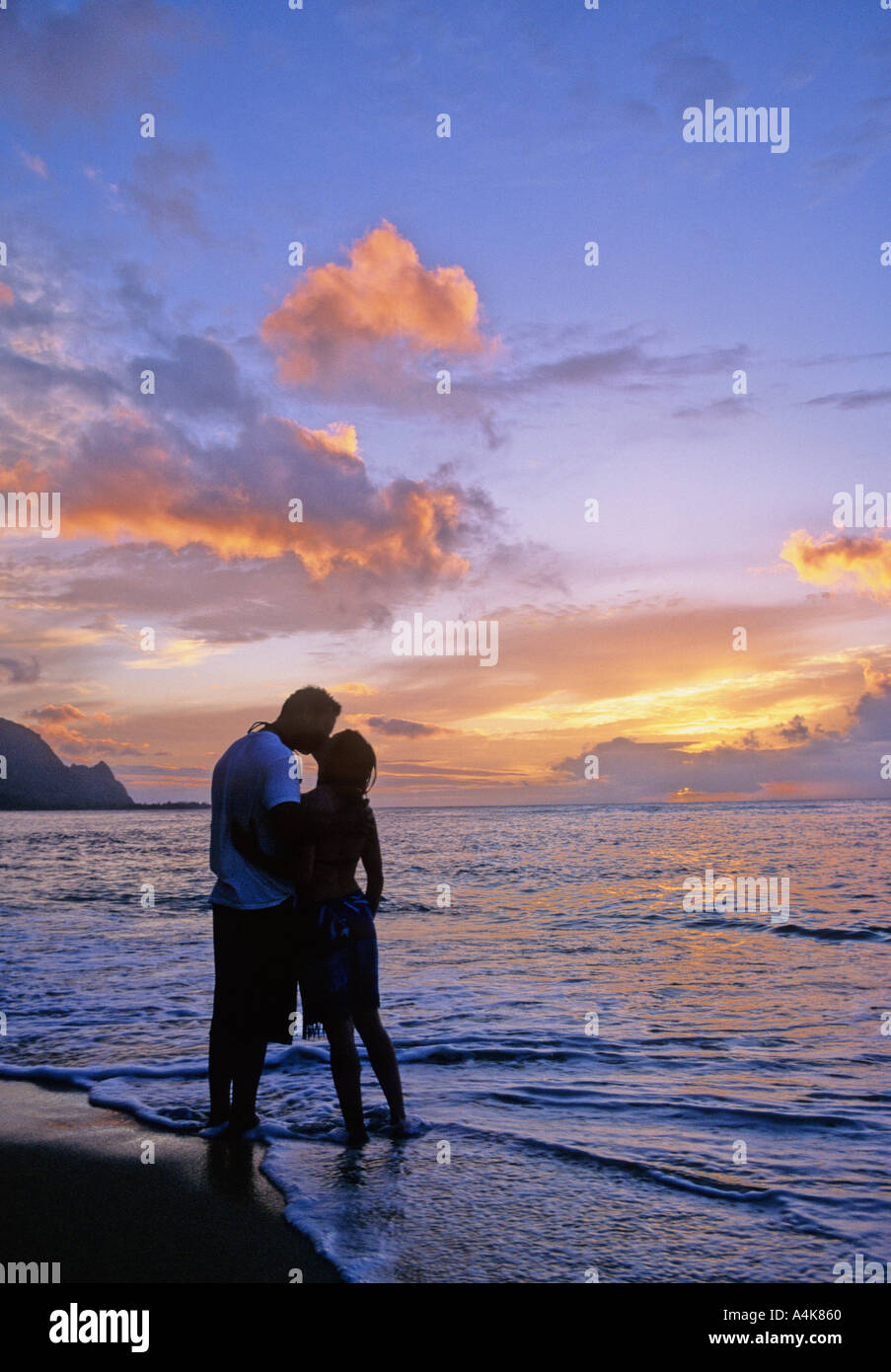 Couple kisses at sunset on Kauai beach Stock Photo Alamy