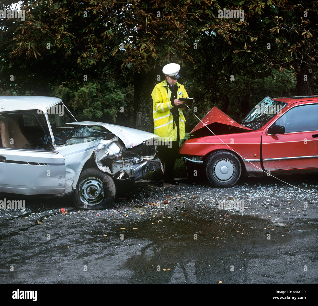 A policement taking measurements at the scene of a road accident. Stock Photo