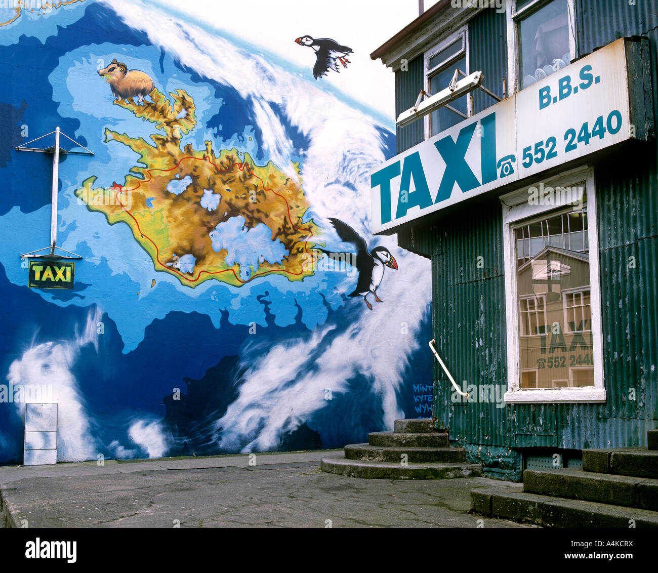 A painted map of Iceland (with puffins) on a wall next to a taxi office, Reykjavik, Iceland. Stock Photo