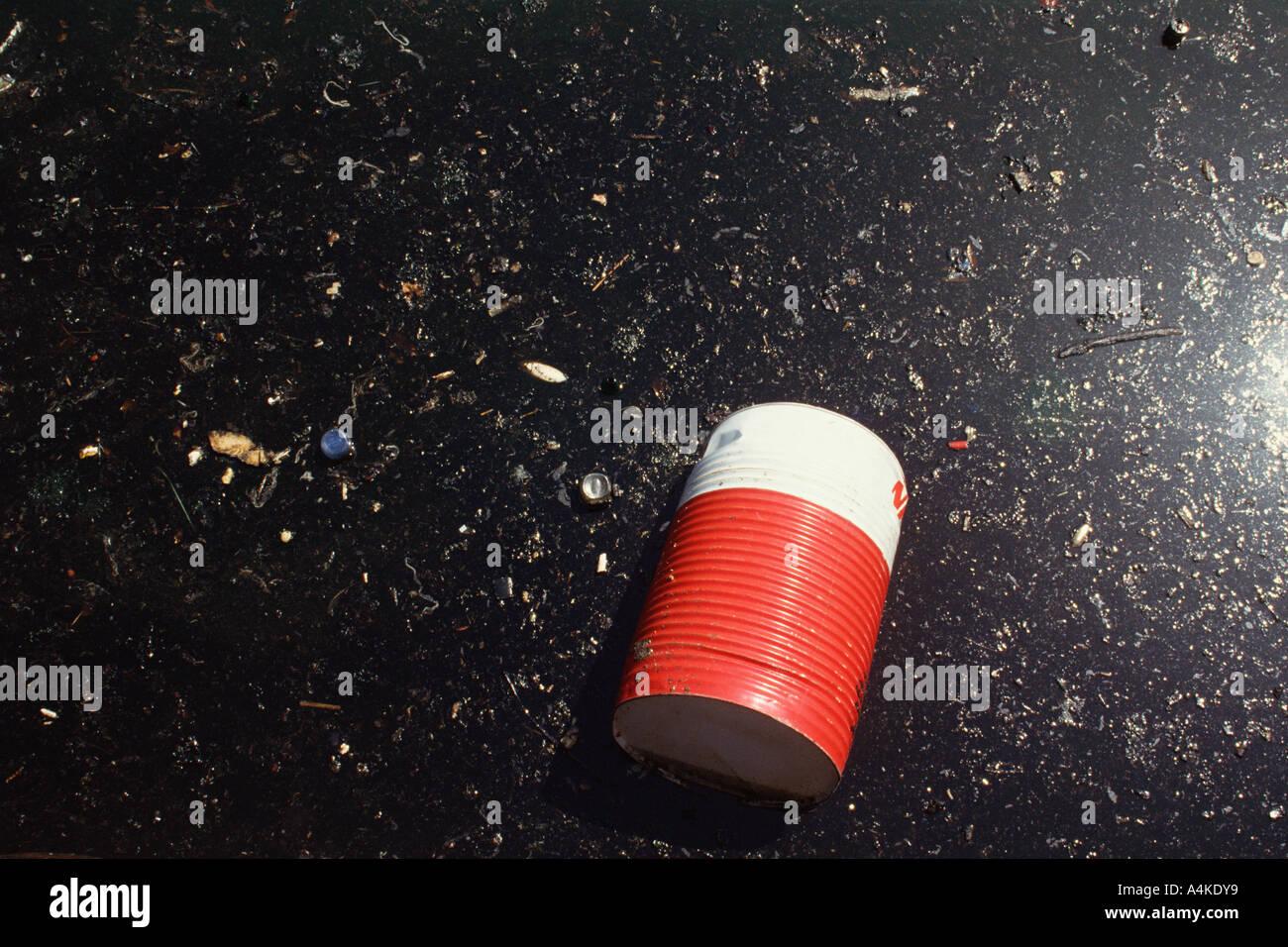 Barrel in oil-polluted water Stock Photo