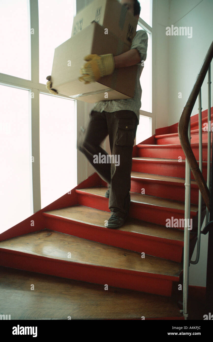 Man carrying boxes down stairs Stock Photo Alamy
