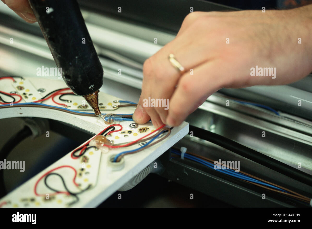 Affixing electrical wires with glue gun Stock Photo Alamy