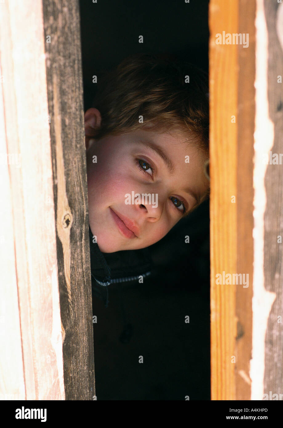 Child peeking through doorway Stock Photo