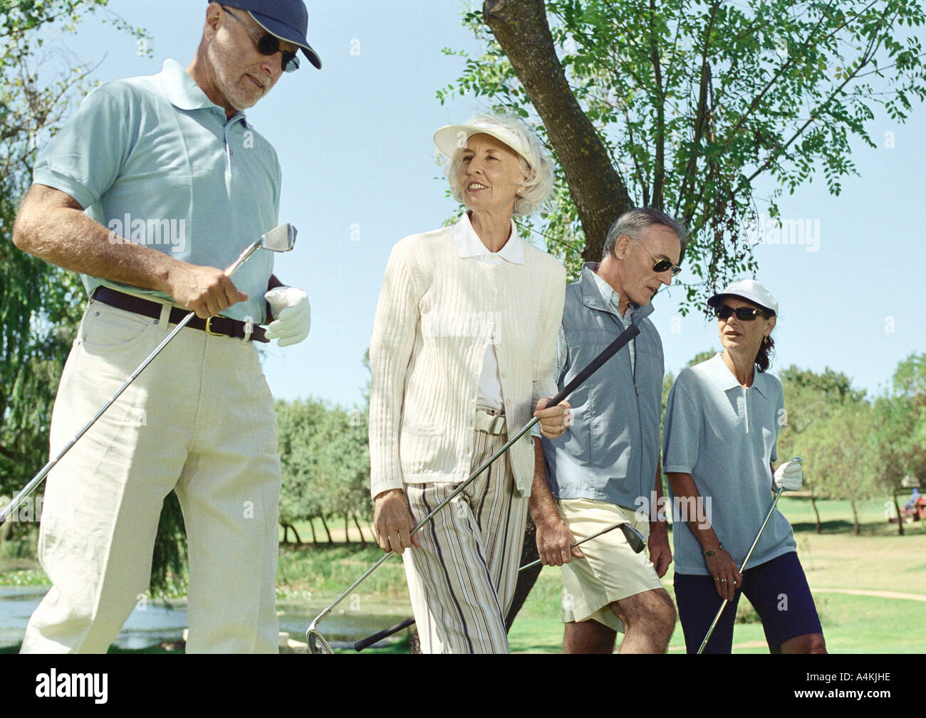 Mature golfers walking side by side Stock Photo