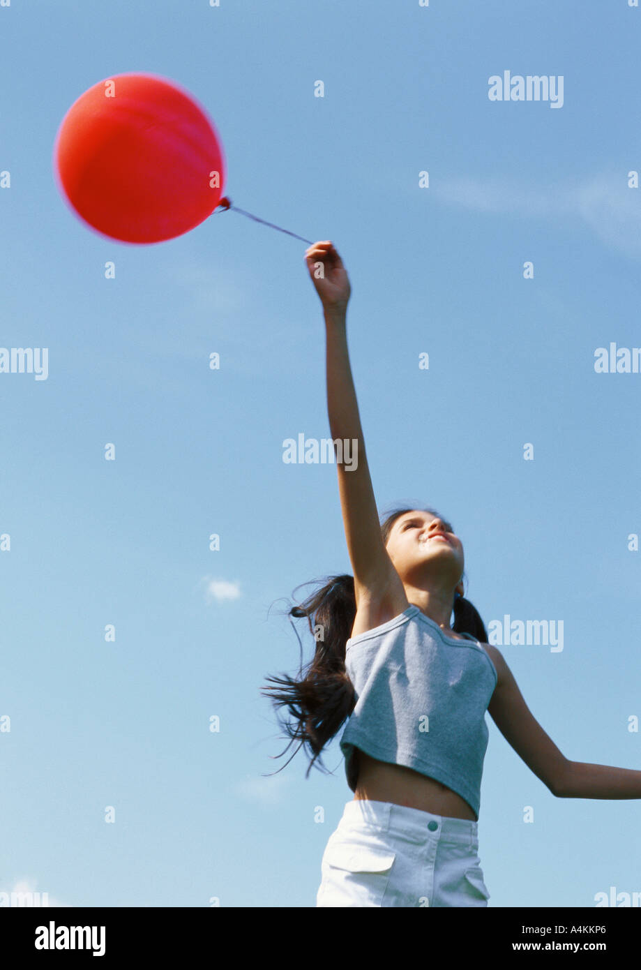 Girl holding red balloon and looking up Stock Photo Alamy