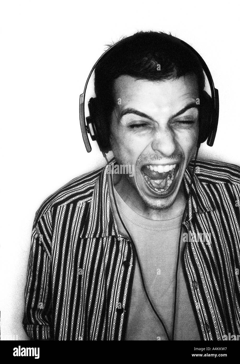 Man listening to headphones with mouth wide open, portrait Stock Photo