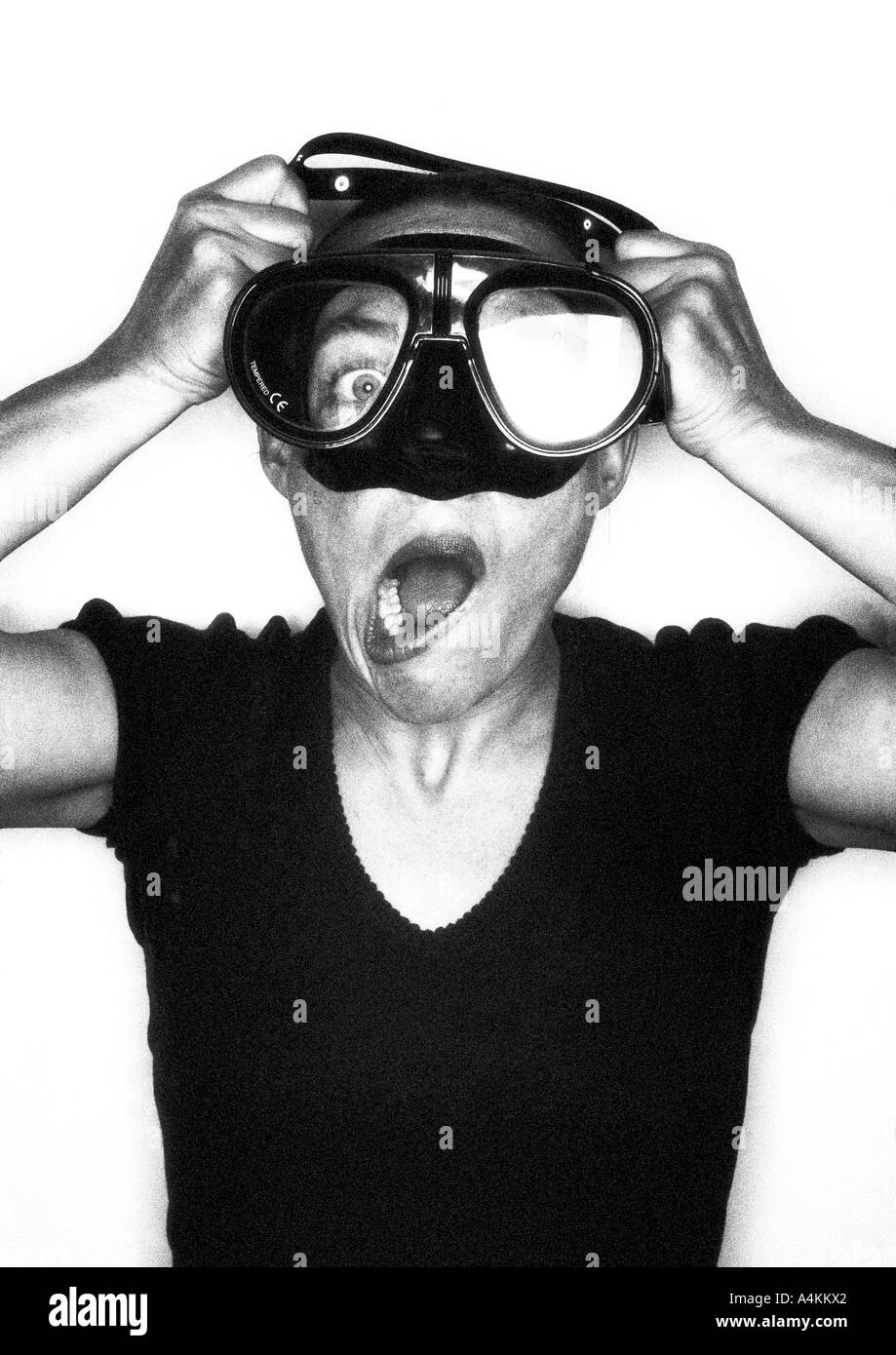 Woman putting on diving goggles, making faces, portrait Stock Photo