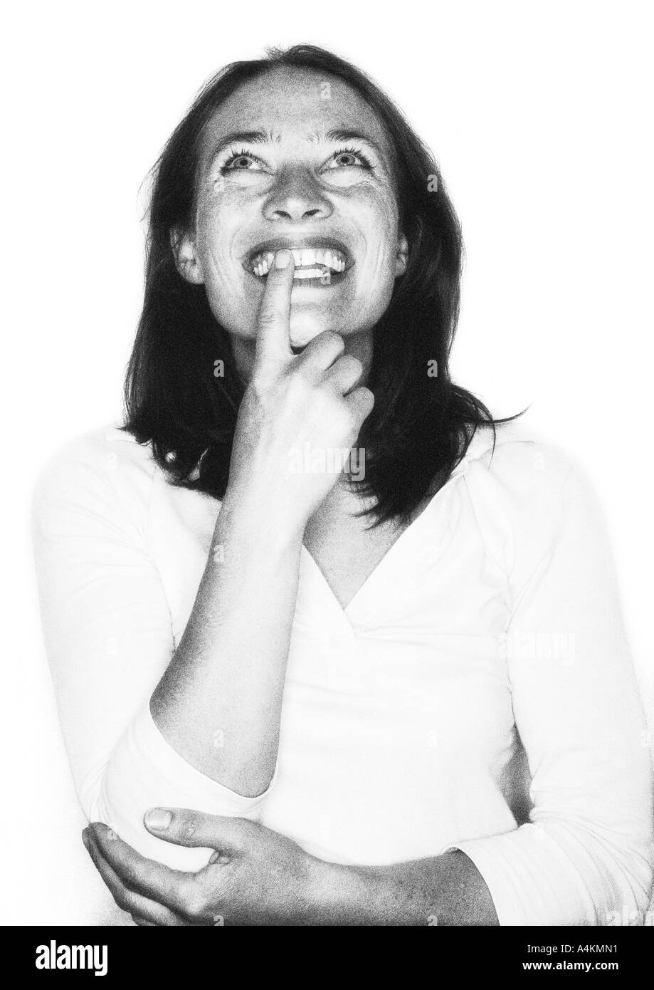 Woman smiling, finger on mouth, portrait, b&w. Stock Photo