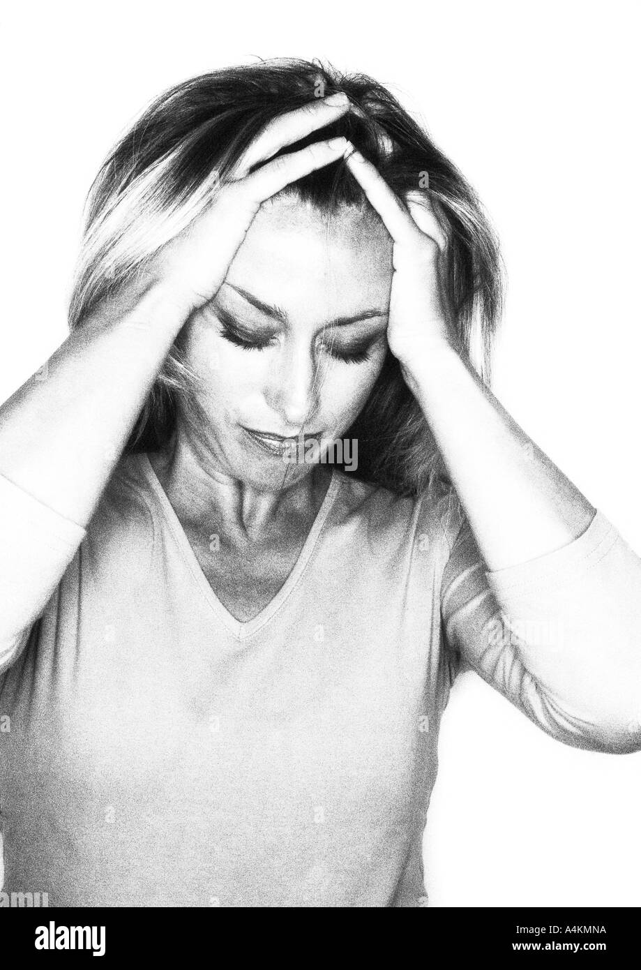 Woman looking down with hands on head, portrait, b&w. Stock Photo