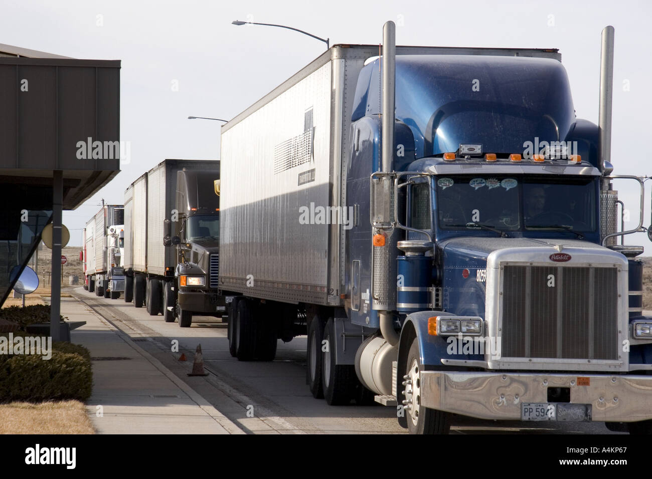 Long haul trucks line up a weigh station Stock Photo Alamy