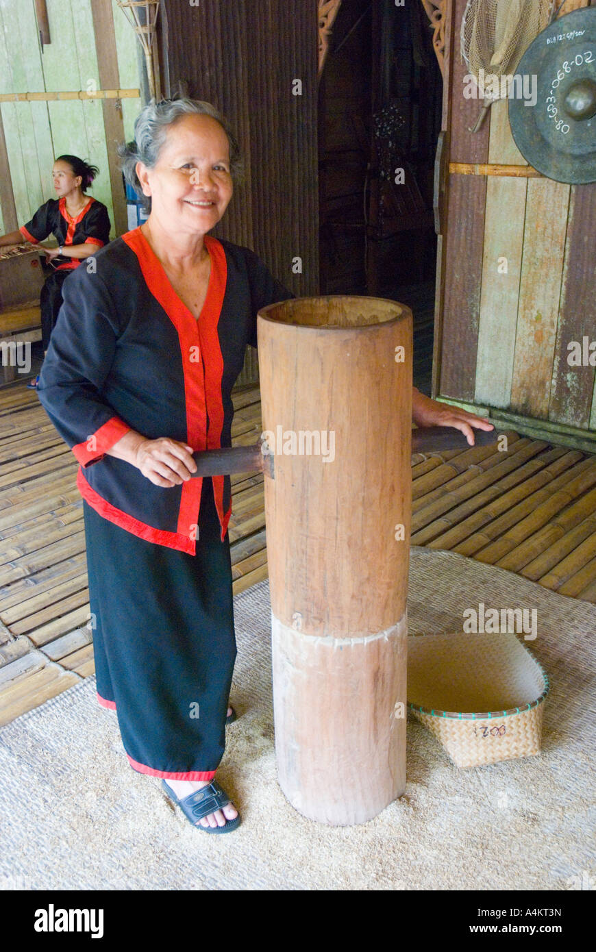 Bidayuh woman with rice grinder at a long house in the Sarawak Cultural Centre Stock Photo