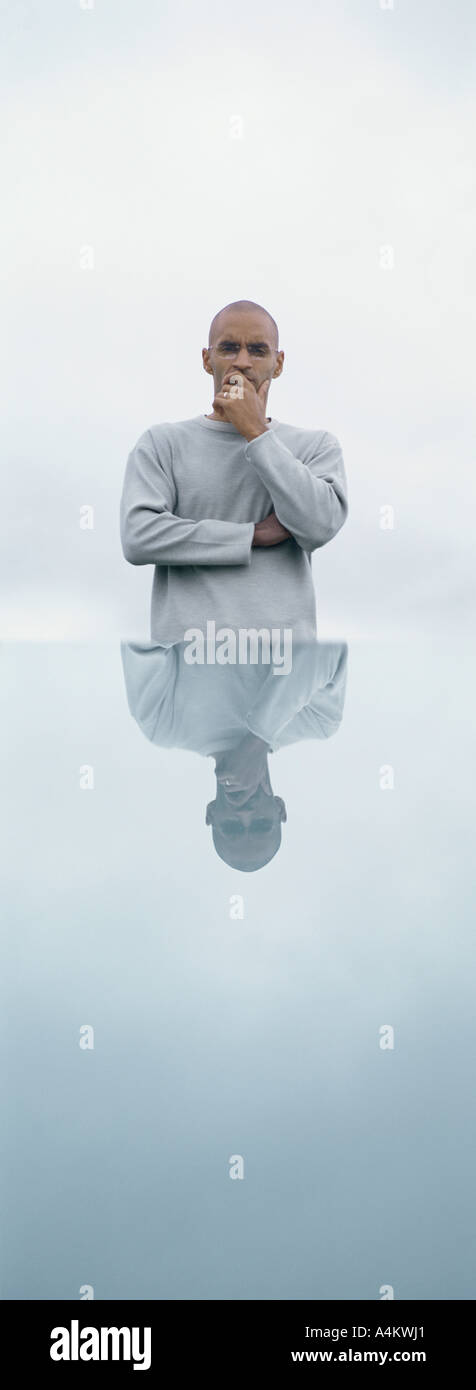 Man standing in front of table with his reflection, outdoors Stock Photo