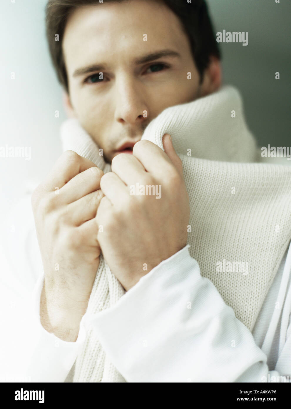 Man holding sweater around neck, covering part of face Stock Photo Alamy