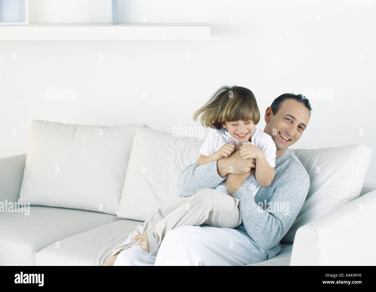 Father holding son on sofa Stock Photo