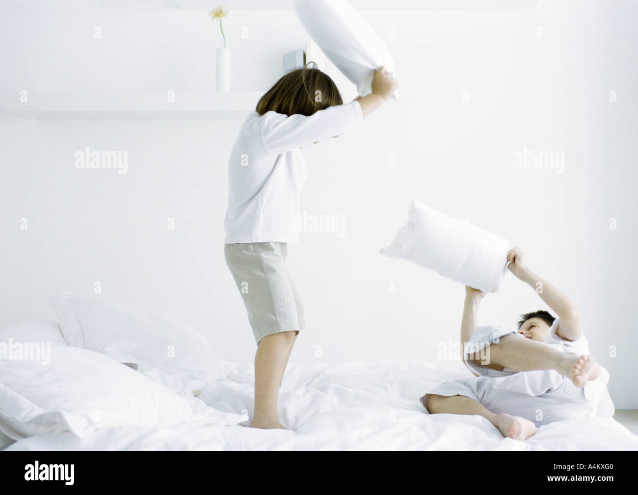 Boys having pillow fight on bed Stock Photo - Alamy