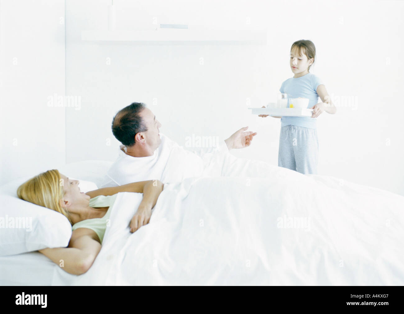 Girl bringing parents breakfast in bed Stock Photo