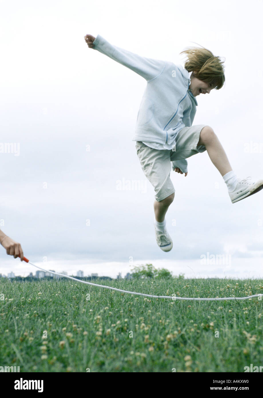 Boy jumping rope on grass, in air Stock Photo Alamy