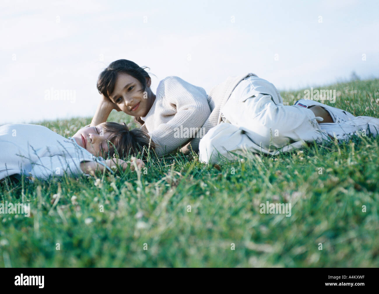 Boy and girl lying on grass Stock Photo