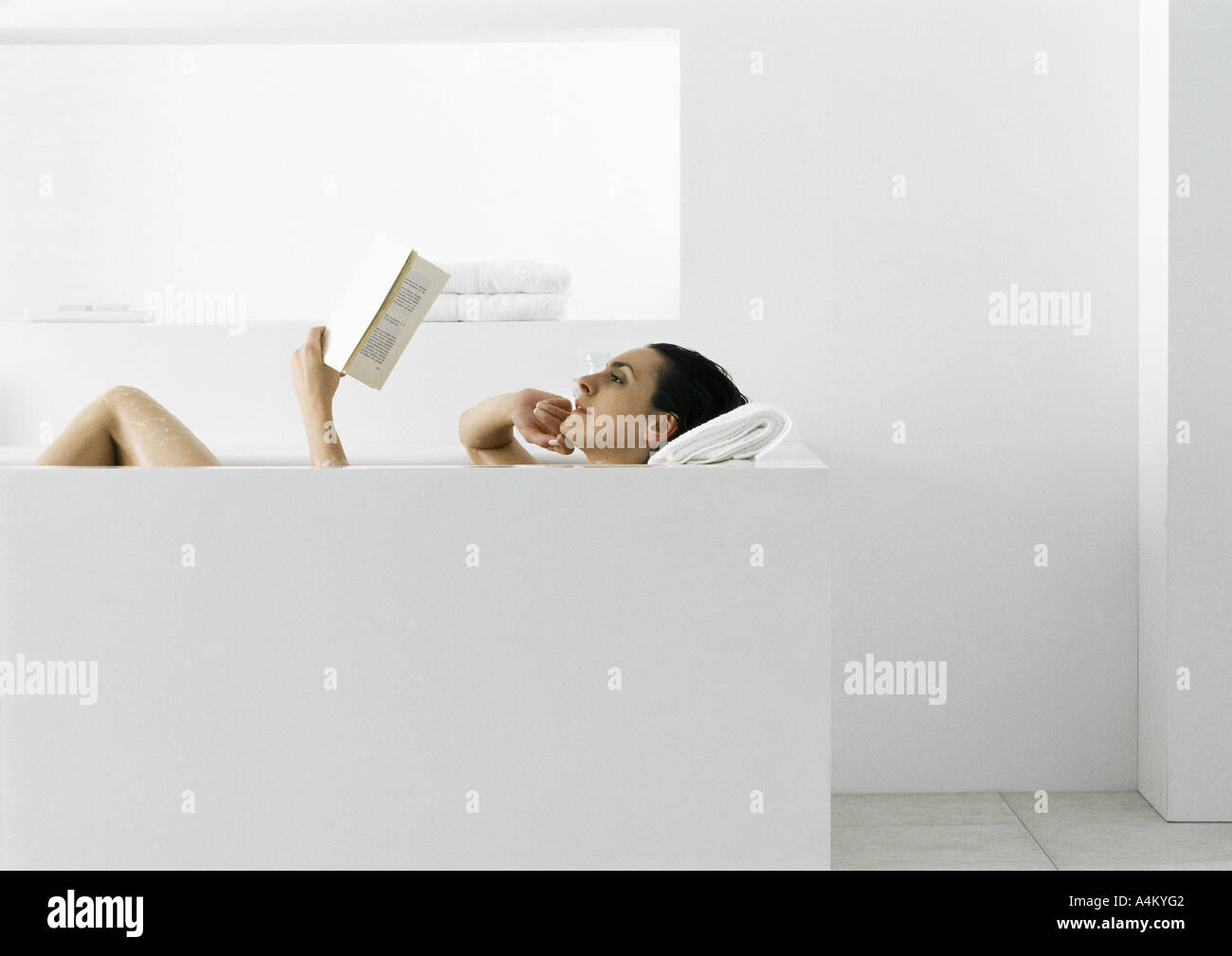 Woman reading in bathtub Stock Photo